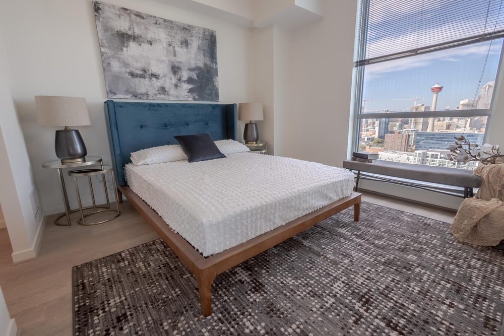 Bedroom with a tufted headboard and city views