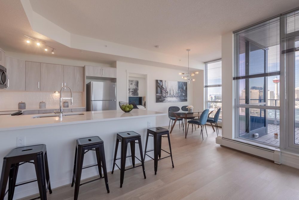 Open kitchen with bar stools and dining area