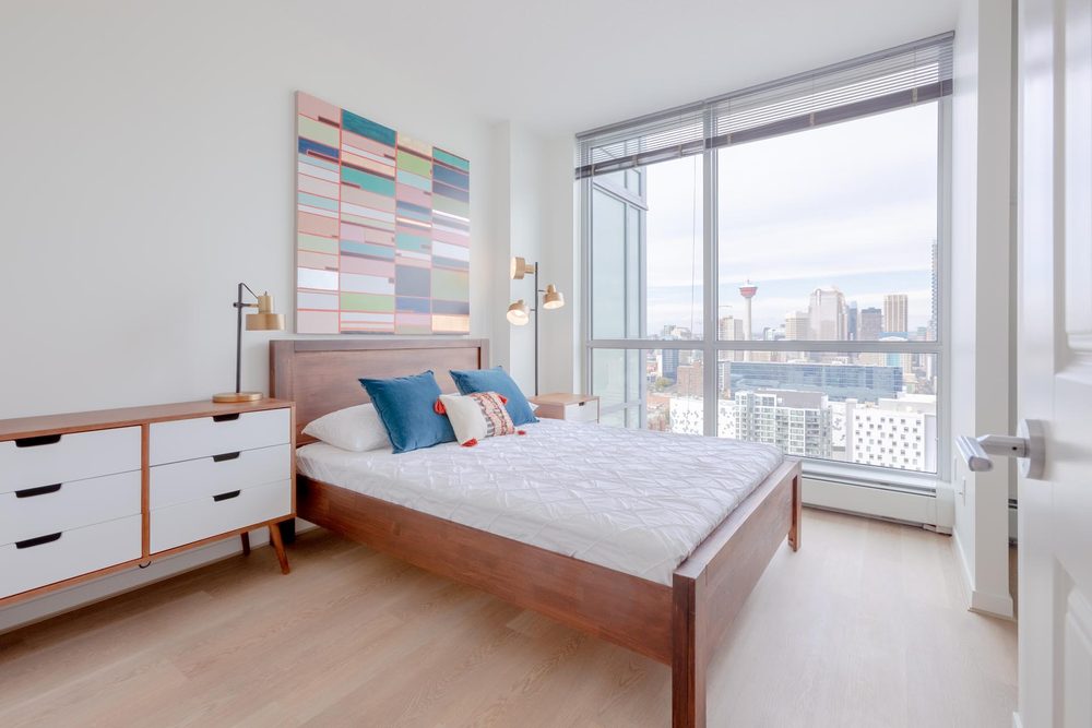Bedroom with a wood dresser and city views