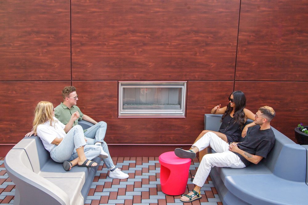 Residents by the fireplace on the rooftop patio